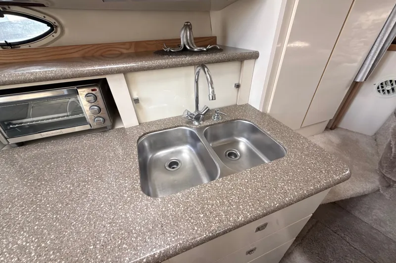 Slide: The Image of 1999 Maxum 3300 SCR yacht kitchen with dual sink and compact oven. - 34