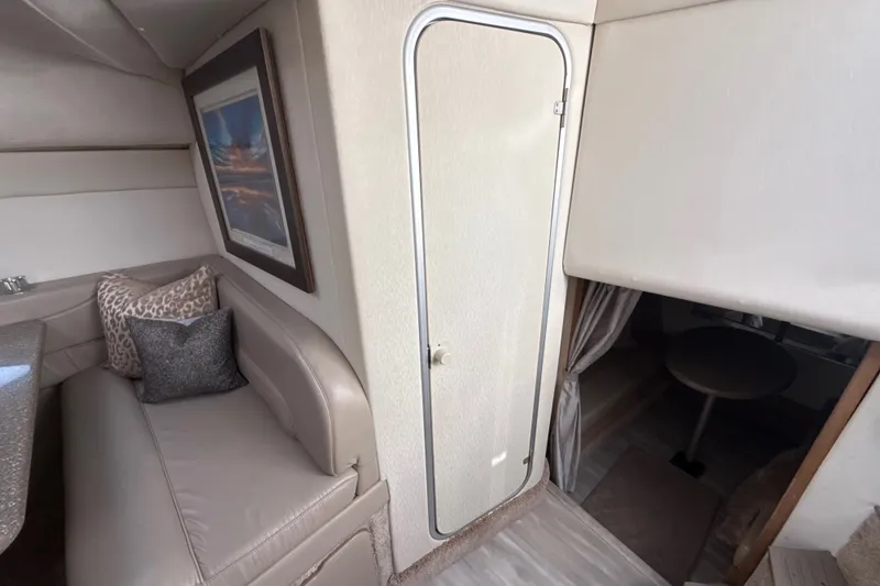 Slide: The Image of 1999 Maxum 3300 SCR cabin interior with seating, pillows, and framed artwork. - 46