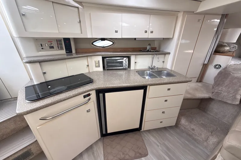 Slide: The Image of Luxurious 1999 Maxum 3300 SCR yacht interior with modern kitchenette and sleek cabinetry. - 32