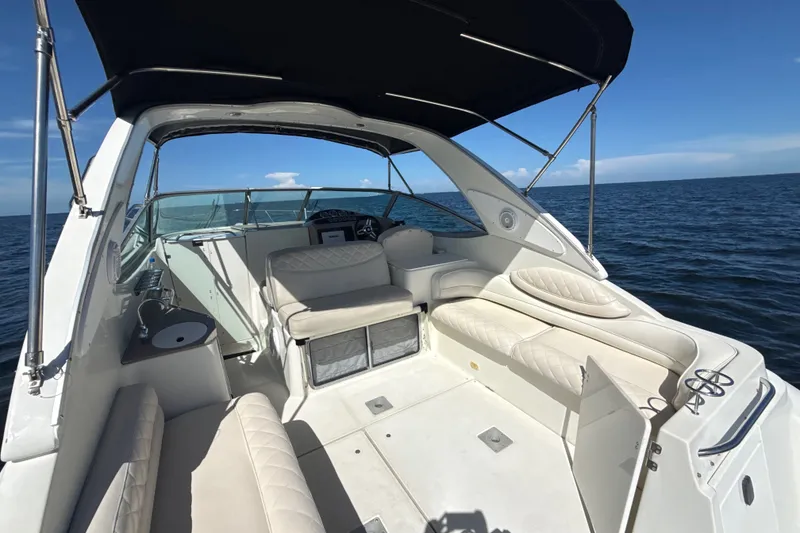 Slide: The Image of 1999 Maxum 3300 SCR yacht interior with white seating, ocean backdrop, and blue sky. - 10