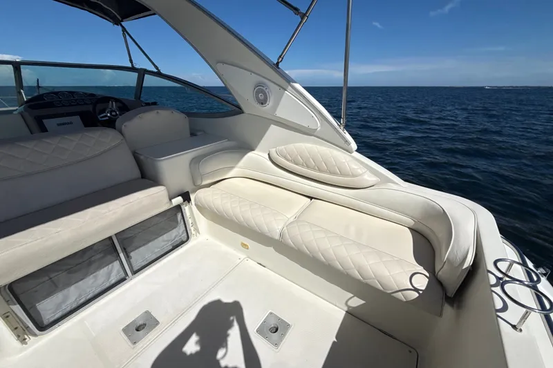 Slide: The Image of 1999 Maxum 3300 SCR boat interior with white seating, ocean view, and clear sky. - 11