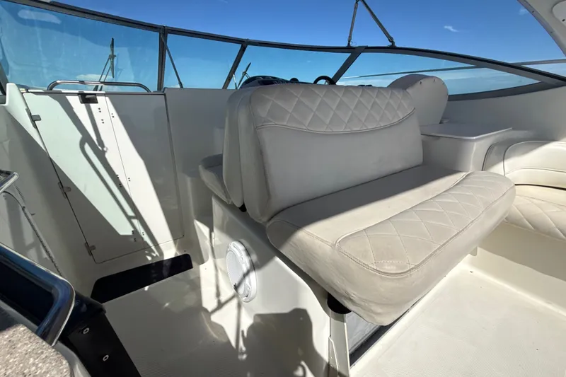 Slide: The Image of 1999 Maxum 3300 SCR boat interior with white leather seating and clear blue sky. - 17