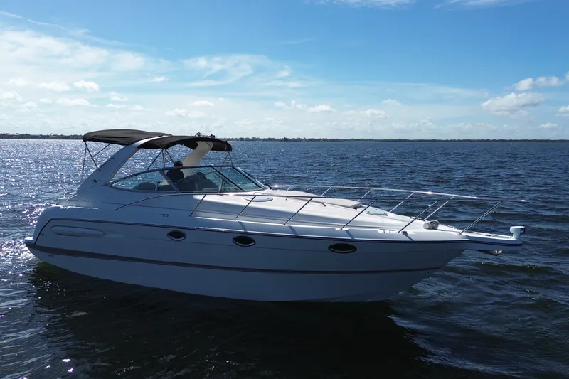 Slide: The Image of 1999 Maxum 3300 SCR boat cruising on a sunny day in open water. - 2