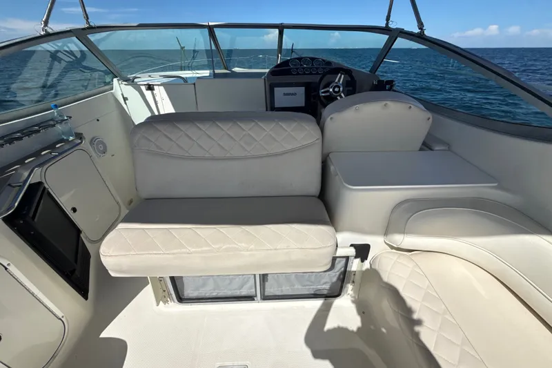 Slide: The Image of 1999 Maxum 3300 SCR boat interior with beige seating and ocean view. - 12