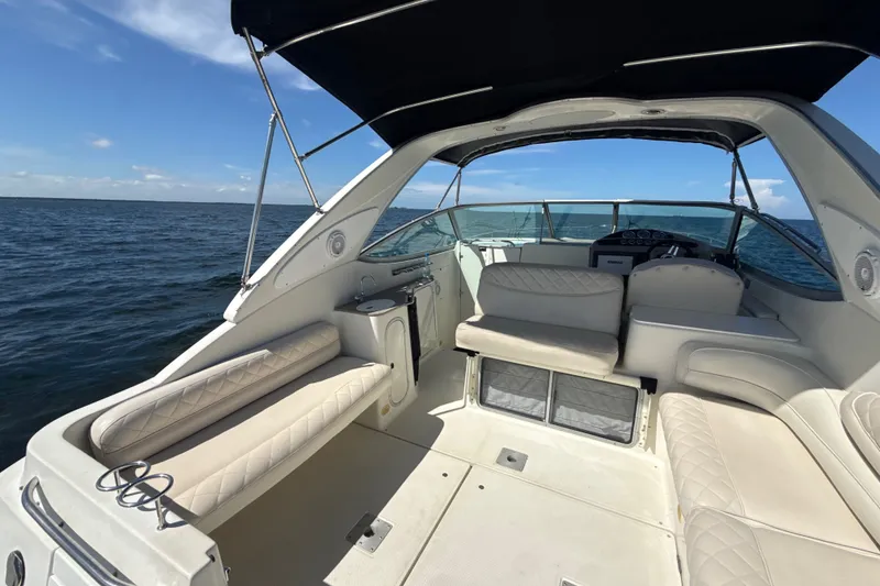 Slide: The Image of 1999 Maxum 3300 SCR boat interior with beige seating, ocean view, and blue sky. - 9