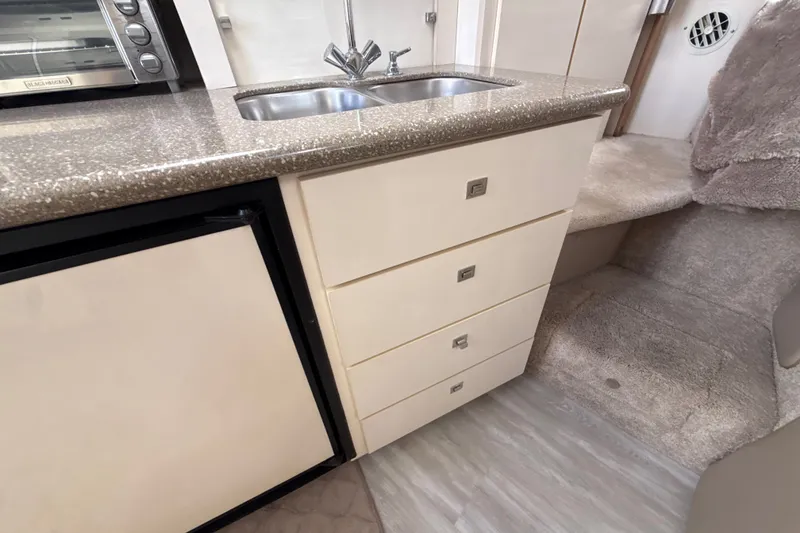 Slide: The Image of 1999 Maxum 3300 SCR boat interior with kitchenette, sink, and storage drawers. - 35