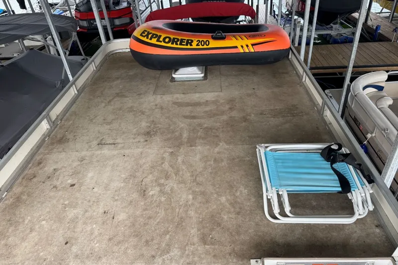 Slide: The Image of 2008 Sun Tracker Party Hut 30 I/O deck with inflatable boat and folding chair. - 31