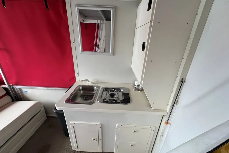 Slide: The Image of 2008 Sun Tracker Party Hut 30 I/O Regency Edition interior with kitchenette and red curtains. - 22