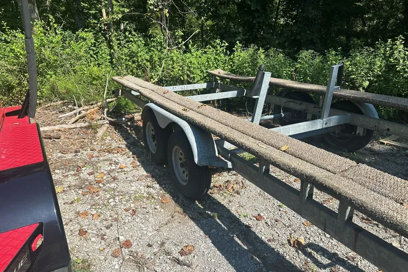 Slide: The Image of Trailer for 2008 Sun Tracker Party Hut 30 I/O Regency Edition, parked on gravel near foliage. - 37