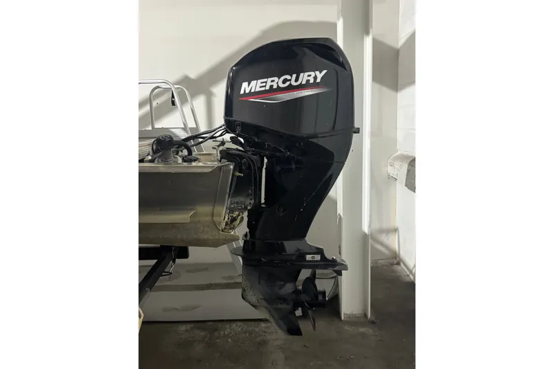 Slide: The Image of 2024 Avalon VLS Quad Lounge boat with Mercury outboard motor in a garage. - 11