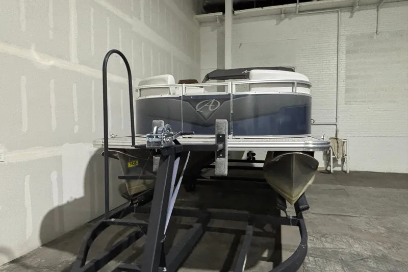 Slide: The Image of 2024 Avalon VLS Quad Lounge 19' pontoon boat in a warehouse setting. - 2
