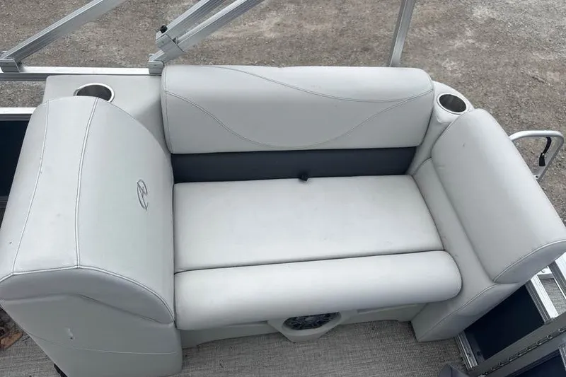 Slide: The Image of 2024 Avalon VLS Quad Lounge boat seat with cup holders, featuring sleek white upholstery. - 5