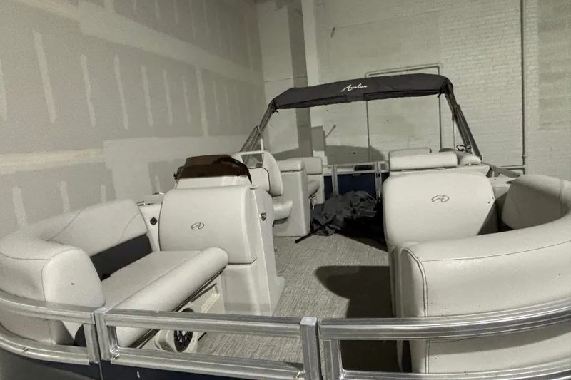 Slide: The Image of 2024 Avalon VLS Quad Lounge 19' pontoon boat with spacious seating in a showroom. - 3