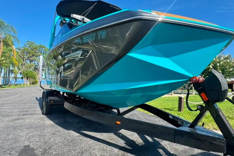 Slide: The Image of 2022 Nautique Super Air Nautique G23 boat on trailer, vibrant blue color, sunny day. - 3
