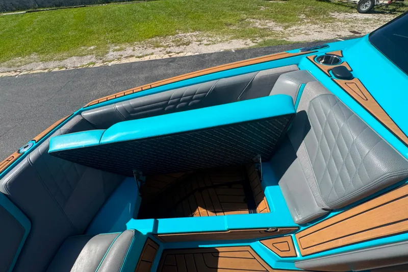 Slide: The Image of 2022 Nautique Super Air Nautique G23 boat interior with turquoise and gray seating. - 96