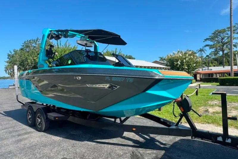 Slide: The Image of 2022 Nautique Super Air Nautique G23 boat on trailer, vibrant blue and gray design. - 2