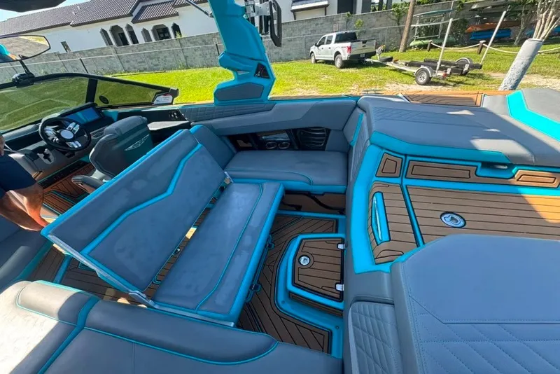 Slide: The Image of 2022 Nautique Super Air Nautique G23 interior with blue accents and modern seating. - 50