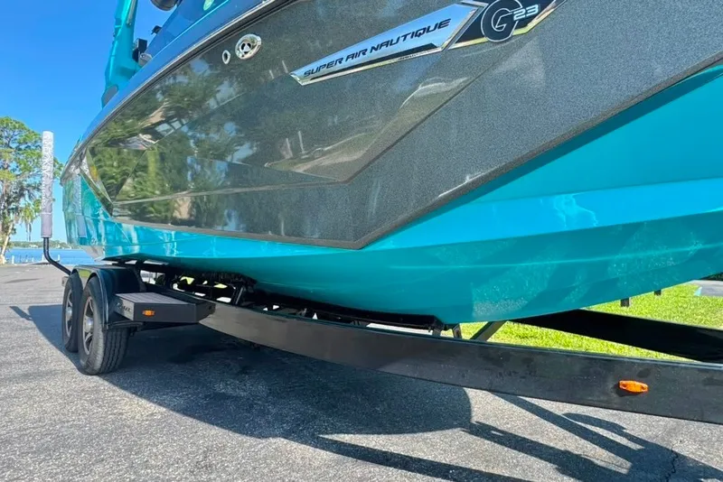 Slide: The Image of 2022 Nautique Super Air Nautique G23 boat on trailer, vibrant blue hull. - 22