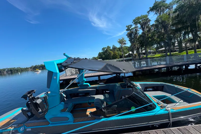 Slide: The Image of 2022 Nautique Super Air Nautique G23 boat docked on a sunny lake. - 54