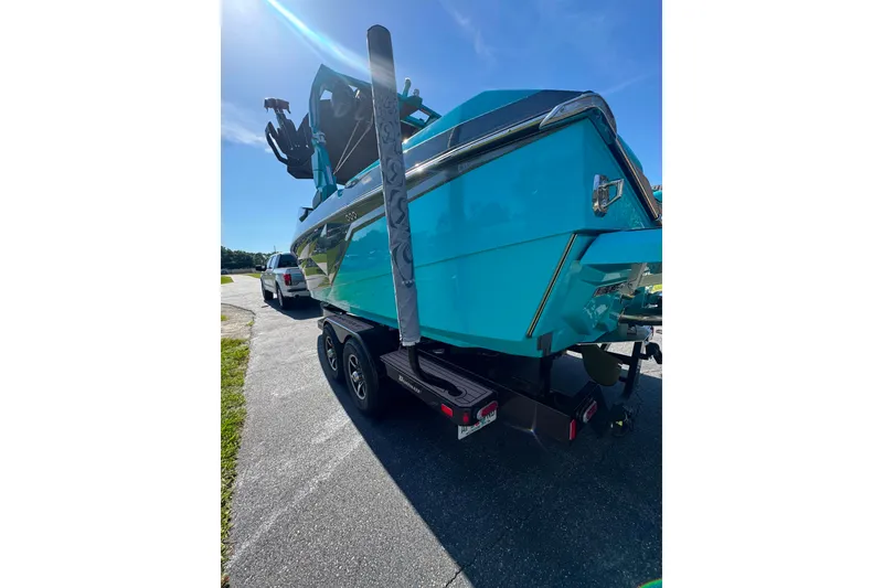 Slide: The Image of 2022 Nautique Super Air Nautique G23 boat on trailer, vibrant blue color, sunny day. - 55
