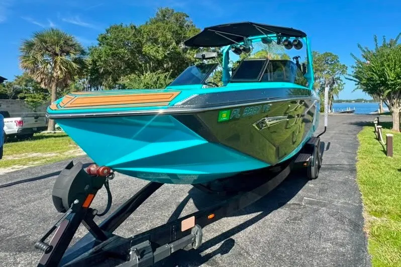 Slide: The Image of 2022 Nautique Super Air Nautique G23 boat on trailer, vibrant blue, sunny day. - 6