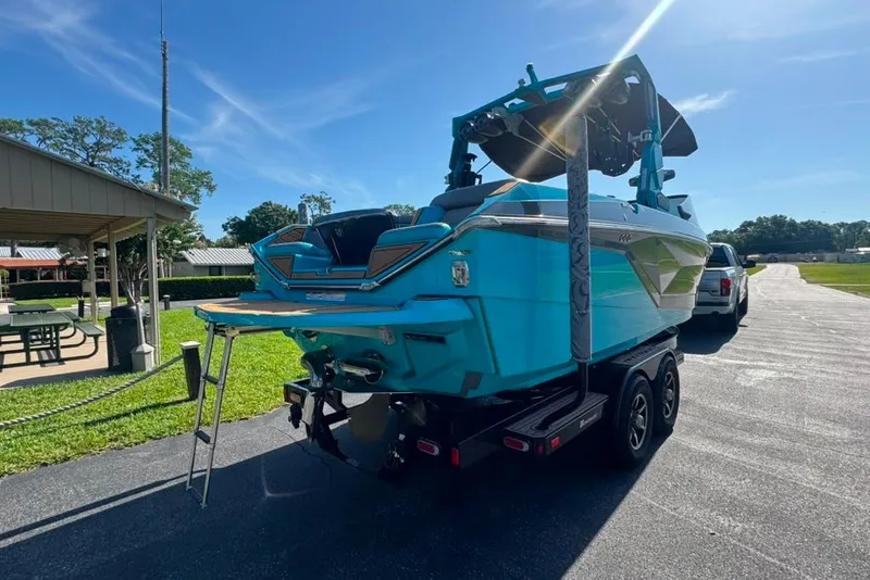 Slide: The Image of 2022 Nautique Super Air Nautique G23 boat on trailer, parked outdoors under clear sky. - 20