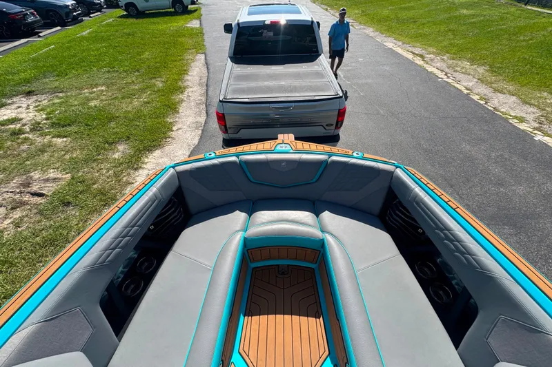 Slide: The Image of 2022 Nautique Super Air Nautique G23 boat interior, parked on a road near a pickup truck. - 61