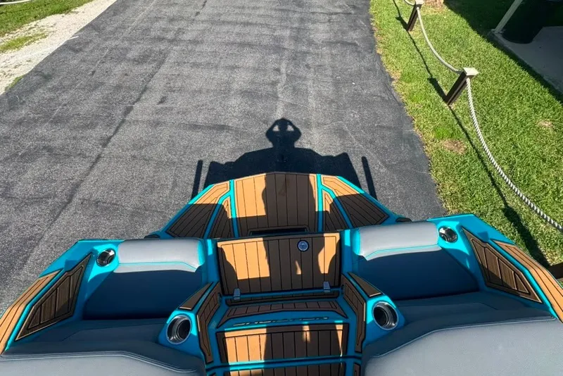 Slide: The Image of 2022 Nautique Super Air Nautique G23 boat interior with teal and wood accents. - 51