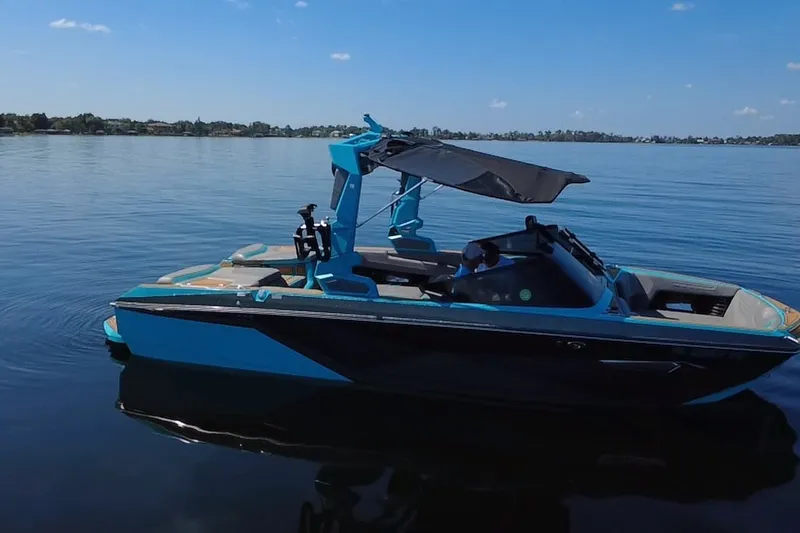 Slide: The Image of 2022 Nautique Super Air Nautique G23 boat on calm lake waters. - 35