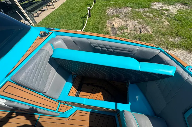 Slide: The Image of 2022 Nautique Super Air Nautique G23 boat interior with turquoise and gray seating. - 75