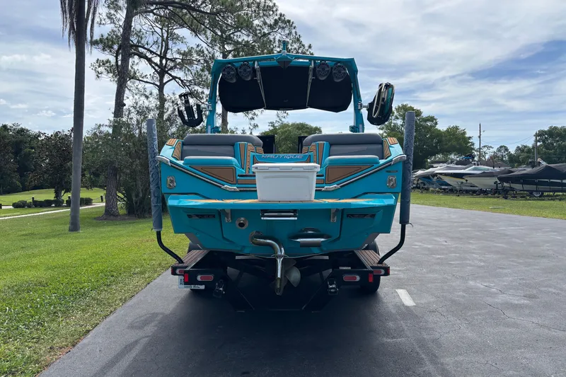 Slide: The Image of 2022 Nautique Super Air Nautique G23 boat, vibrant blue, parked on a driveway. - 15