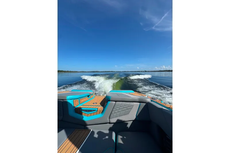 Slide: The Image of 2022 Nautique Super Air Nautique G23 cruising on a clear, sunny lake. - 98