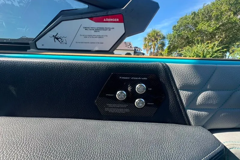 Slide: The Image of Interior view of 2022 Nautique Super Air Nautique G23 boat with control panel and safety warning. - 44