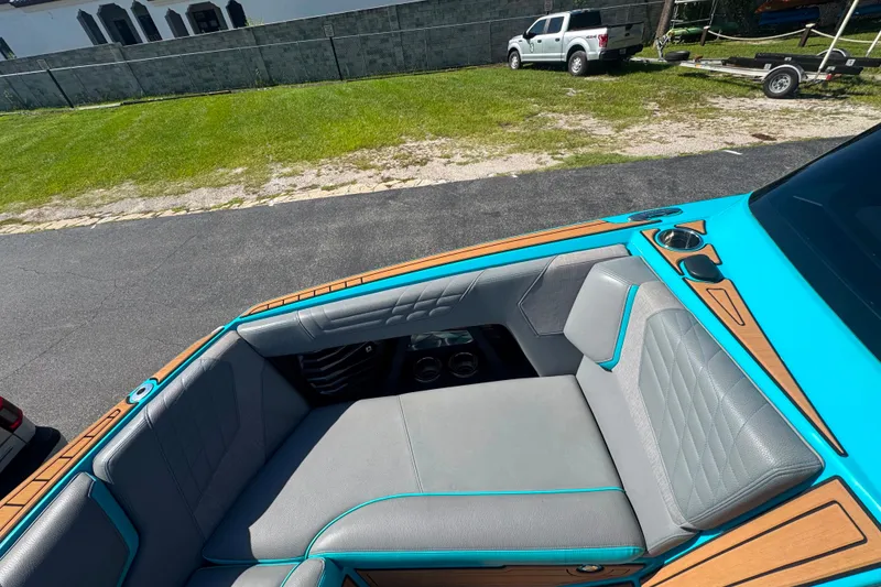 Slide: The Image of 2022 Nautique Super Air Nautique G23 boat interior with teal and gray seating. - 117