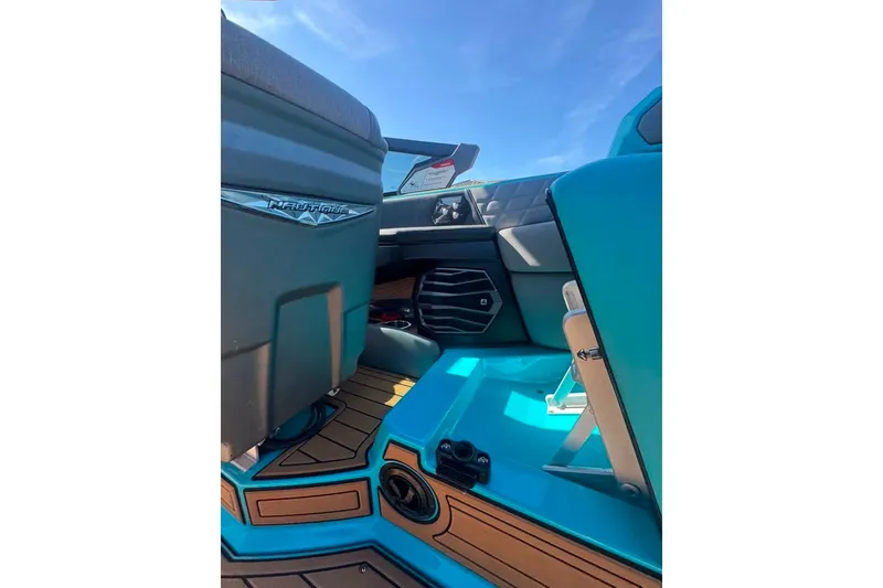 Slide: The Image of 2022 Nautique Super Air Nautique G23 interior with turquoise and wood accents under blue sky. - 80