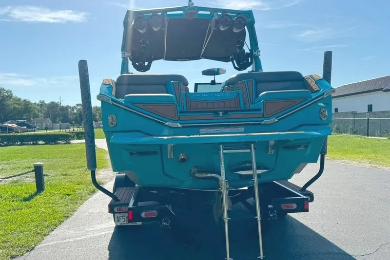 Slide: The Image of The image shows the rear of a blue 2022 Nautique Super Air Nautique G23 boat. - 14