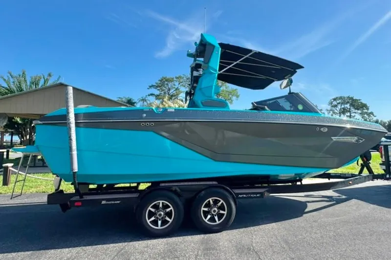 Slide: The Image of 2022 Nautique Super Air Nautique G23 boat on trailer, vibrant blue and gray design. - 21