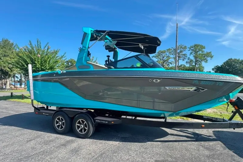 Slide: The Image of 2022 Nautique Super Air Nautique G23 boat on trailer, vibrant blue and gray design. - 1