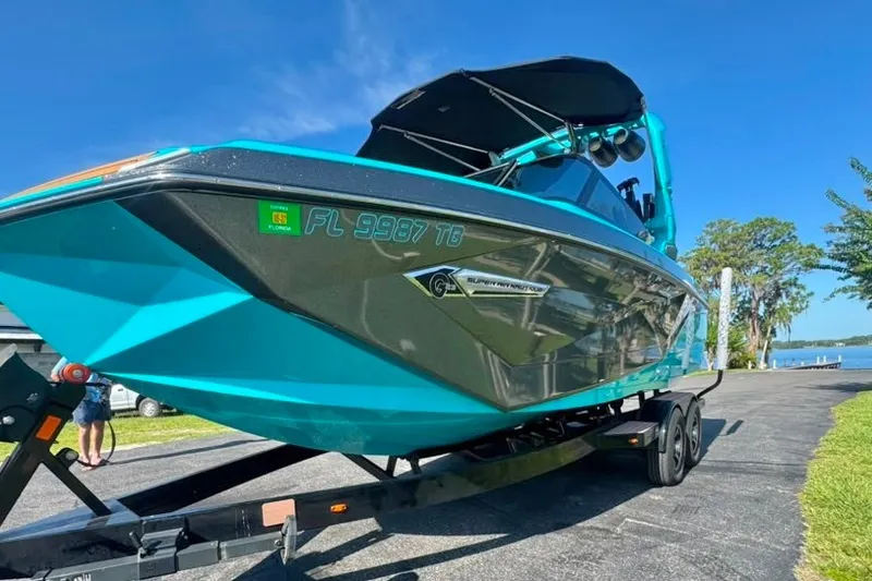 Slide: The Image of 2022 Nautique Super Air Nautique G23 boat on trailer, vibrant blue color. - 8