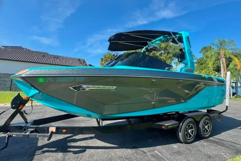Slide: The Image of 2022 Nautique Super Air Nautique G23 boat on trailer, vibrant blue and gray design. - 10