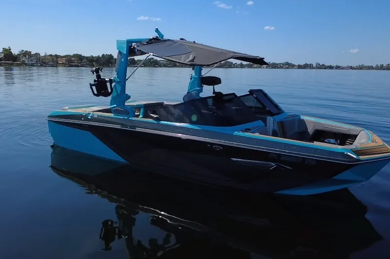 Slide: The Image of 2022 Nautique Super Air Nautique G23 boat on calm lake under clear sky. - 45