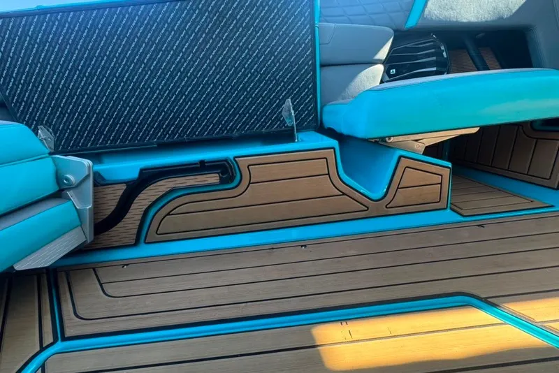 Slide: The Image of 2022 Nautique Super Air Nautique G23 interior with teal accents and wood-style flooring. - 89