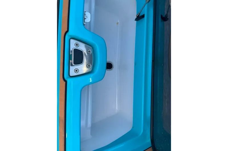 Slide: The Image of 2022 Nautique Super Air Nautique G23 storage compartment with blue trim and stainless steel latch. - 63