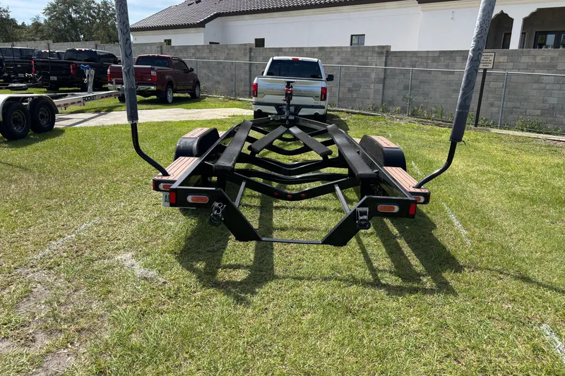 Slide: The Image of Trailer for 2022 Nautique Super Air Nautique G23 on grass, near parked vehicles. - 31