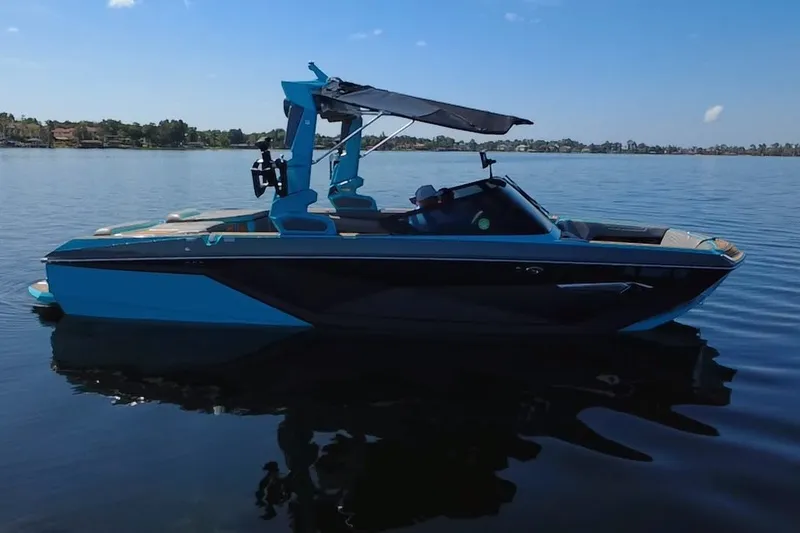Slide: The Image of 2022 Nautique Super Air Nautique G23 boat on calm lake waters. - 59