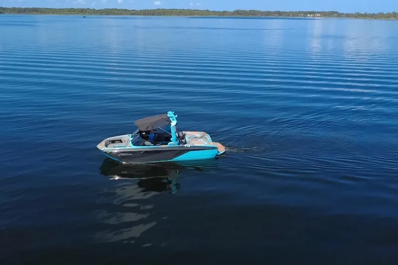 Slide: The Image of 2022 Nautique Super Air Nautique G23 boat cruising on calm blue water. - 94