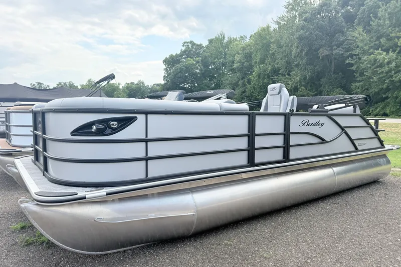 The Image of 2027 Bentley Pontoons LEGACY 220 QSB pontoon boat parked on a gravel surface. - 0