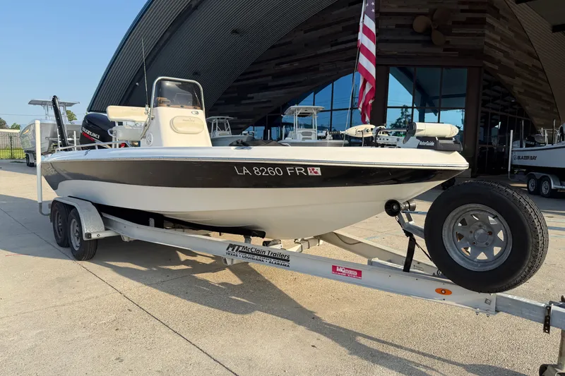 Slide: The Image of 2007 NauticStar 2200 NauticBay boat on trailer, parked outside a modern building. - 2