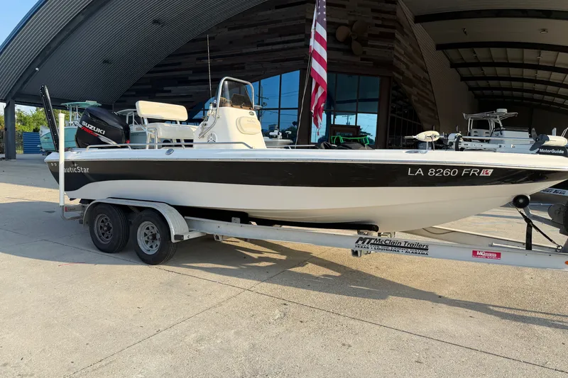 Slide: The Image of 2007 NauticStar 2200 NauticBay boat on trailer, parked outside a modern building. - 1