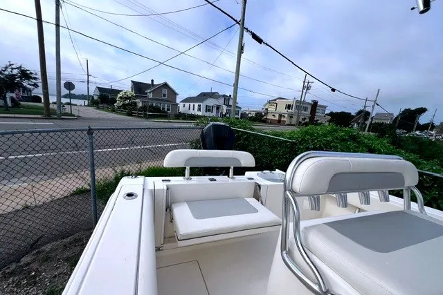 Slide: The Image of 2020 Cobia 237 Center Console boat parked near residential area, showcasing seating and console. - 8